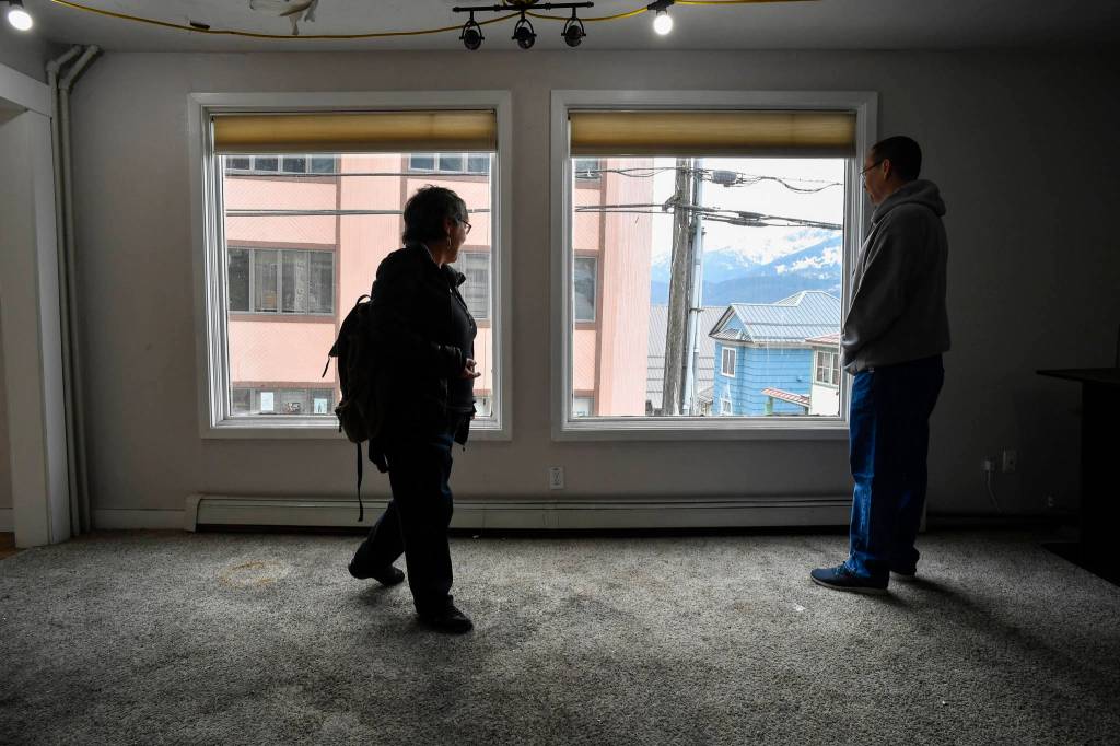 Ernestine Hayes, with her son, Joshua Stephenson, gives a tour of her fire-damaged house at the corner of Fifth and Franklin Street on Wednesday, April 3, 2019. (Michael Penn | Juneau Empire)