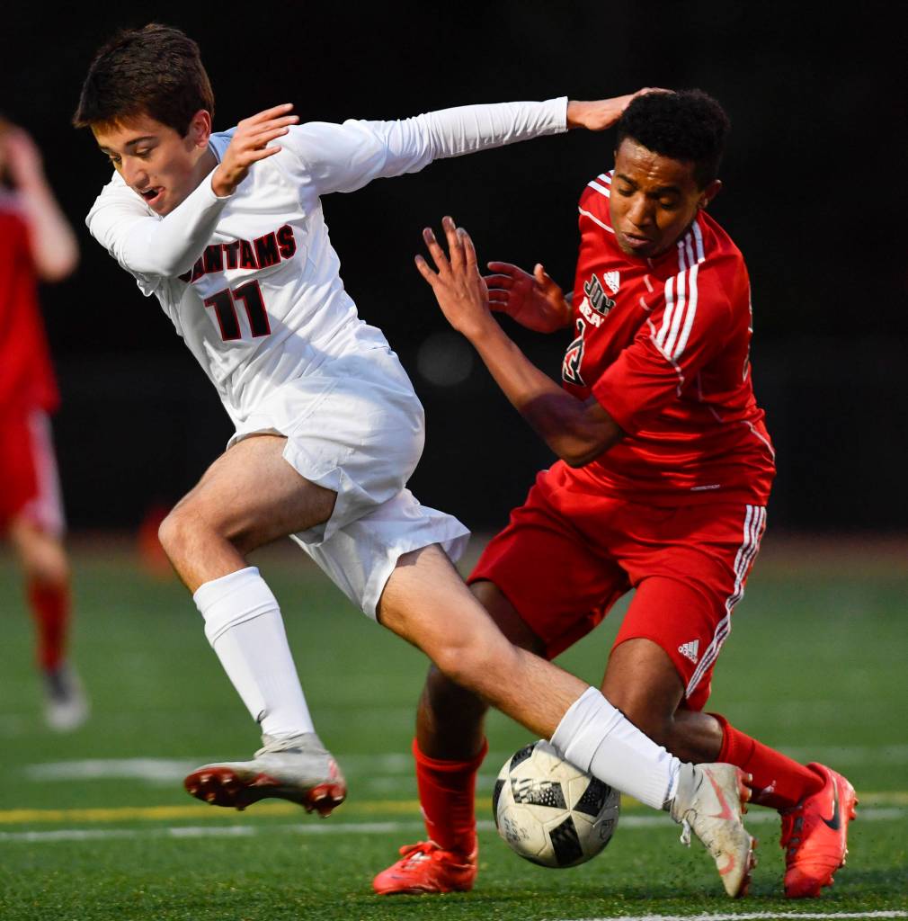Juneau-Douglas Finn Yerkes, right, competes against Clarkstons Robert Hubbard at Adair-Kennedy Memorial Field on Wednesday, April 3, 2019. Clarkston won 1-0. (Michael Penn | Juneau Empire)