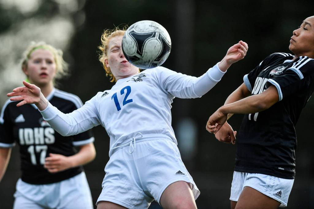 Thunder Mountains Emily Heaton, center, controls the ball against Juneau-Douglas Malia Miller, right, at Adair-Kennedy Memorial Field on Wednesday, April 3, 2019. JDHS won 8-0. (Michael Penn | Juneau Empire)