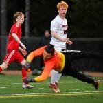 Juneau-Douglas Kanon Goetz, left, watches his shot go wide of the goal as Clarksons goalie Alessandro Italia dives for it at Adair-Kennedy Memorial Field on Wednesday, April 3, 2019. Clarkson won 1-0. (Michael Penn | Juneau Empire)