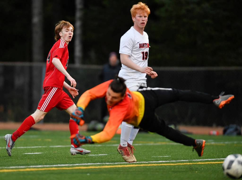 Juneau-Douglas Kanon Goetz, left, watches his shot go wide of the goal as Clarksons goalie Alessandro Italia dives for it at Adair-Kennedy Memorial Field on Wednesday, April 3, 2019. Clarkson won 1-0. (Michael Penn | Juneau Empire)