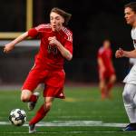 Juneau-Douglas Kanon Goetz, left, races against Clarksons Nate Hoffman at Adair-Kennedy Memorial Field on Wednesday, April 3, 2019. Clarkson won 1-0. (Michael Penn | Juneau Empire)