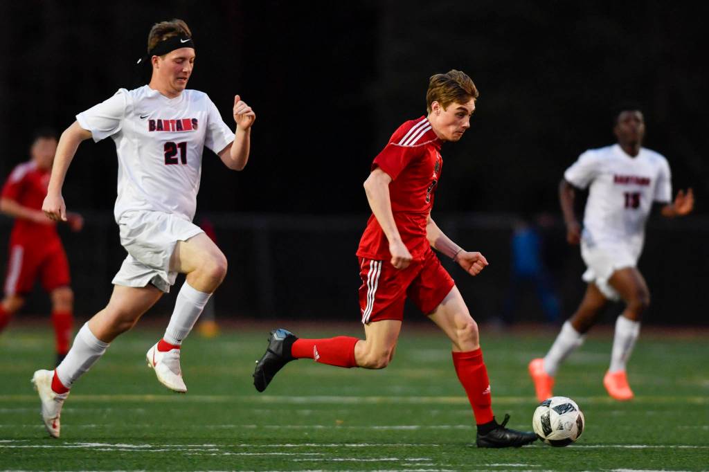 Juneau-Douglas Koby Goldstein, right races against Clarksons Hayden Rogers at Adair-Kennedy Memorial Field on Wednesday, April 3, 2019. Clarkson won 1-0. (Michael Penn | Juneau Empire)