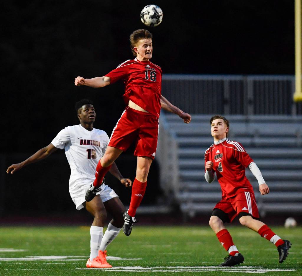 Juneau-Douglas Clem Taylor-Roth heads the ball in front of Clarksons Steve Baiye at Adair-Kennedy Memorial Field on Wednesday, April 3, 2019. Clarkson won 1-0. (Michael Penn | Juneau Empire)