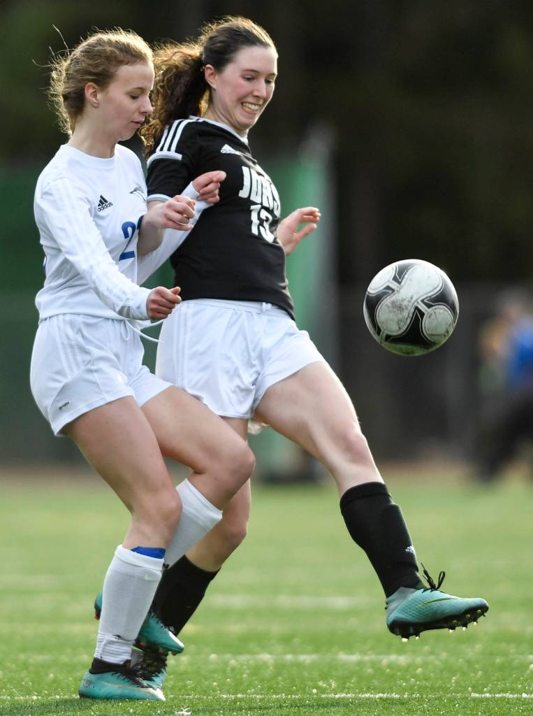 Juneau-Douglas Nicole Mannix, right, kicks the ball away from Thunder Mountains Isabella Hanna at Adair-Kennedy Memorial Field on Wednesday, April 3, 2019. JDHS won 8-0. (Michael Penn | Juneau Empire)