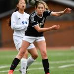 Juneau-Douglas Jessie Mayer heads the ball away from Thunder Mountains Molly Brocious at Adair-Kennedy Memorial Field on Wednesday, April 3, 2019. JDHS won 8-0. (Michael Penn | Juneau Empire)
