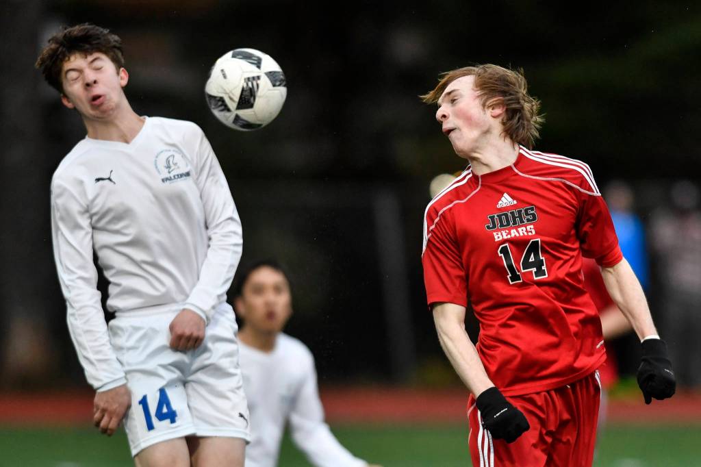 Juneau-Douglas Kanon Goetz, right, heads the ball toward the goal as Thunder Mountains Jake Babcock trys to block at Adair-Kennedy Memorial Field on Wednesday, April 17, 2019. Thunder Mountain won 2-1. (Michael Penn | Juneau Empire)