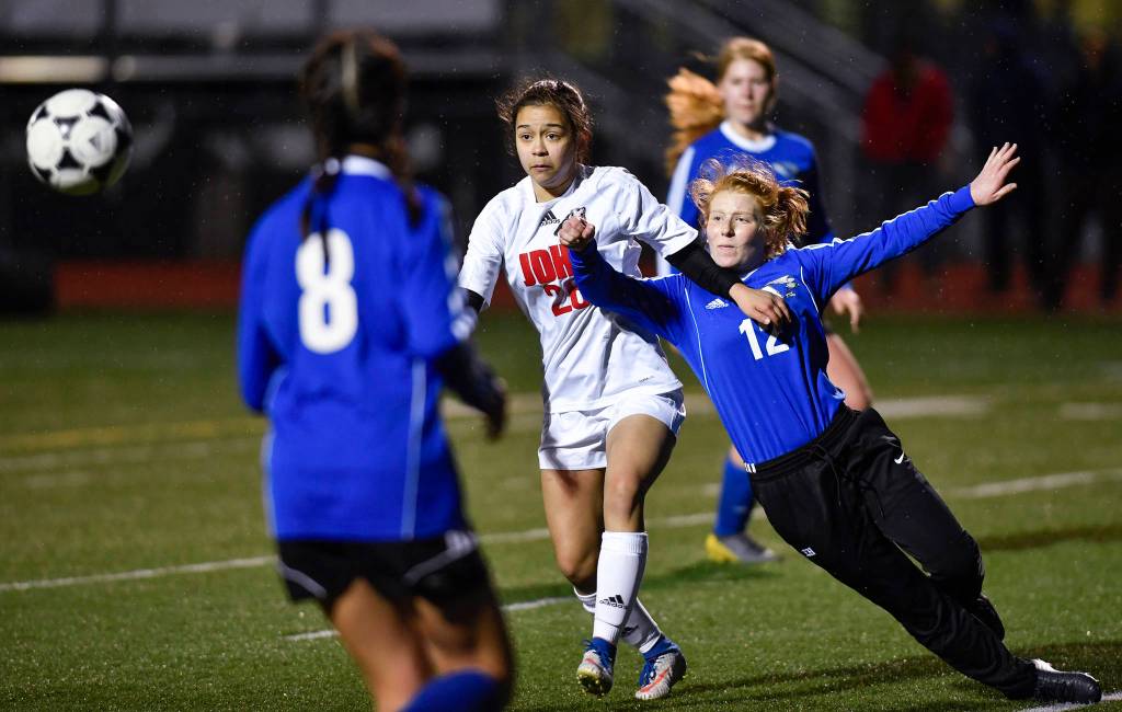 Thunder Mountains Emily Heaton, right, attempts to block Juneau-Douglas Blake Plummer from the ball at TMHS on Wednesday, April 17, 2019. JDHS won 5-0. (Michael Penn | Juneau Empire)
