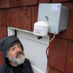 Mike Hekkers looks at an air quality measurement device that was installed by the Department of Environmental Conservation at his downtown Juneau home on Thursday, April 18, 2019. The device, along with a number of others, will measure air quality in downtown during this summers cruise ship season. (Michael Penn |Juneau Empire)