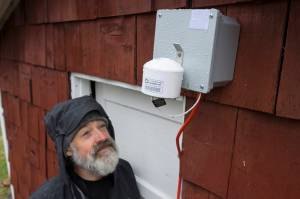 Mike Hekkers looks at an air quality measurement device that was installed by the Department of Environmental Conservation at his downtown home on Thursday, April 18, 2019. The device, along with a number of others, will measure air quality in downtown during this summers cruise ship season. (Michael Penn |Juneau Empire)