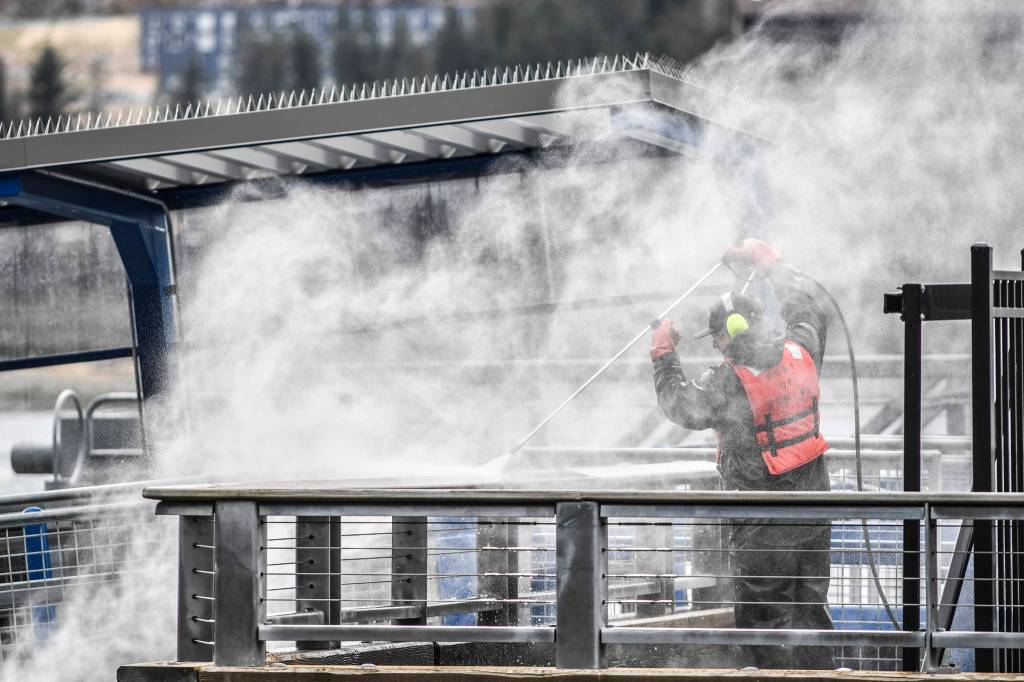 Tal Novell, a city Docks and Harbor employee, pressure washes railings at the cruise ship terminal on Monday, April 15, 2019. (Michael Penn | Juneau Empire)
