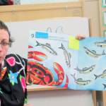 Mary Daaljíni Folletti, lead instructor and administrator for the Tlingit-language preschool Haa Yoo Xatángi Kúdi, reads a story, 10 Sitka Herring, to children during a family night event, Monday, April 22, 2019.