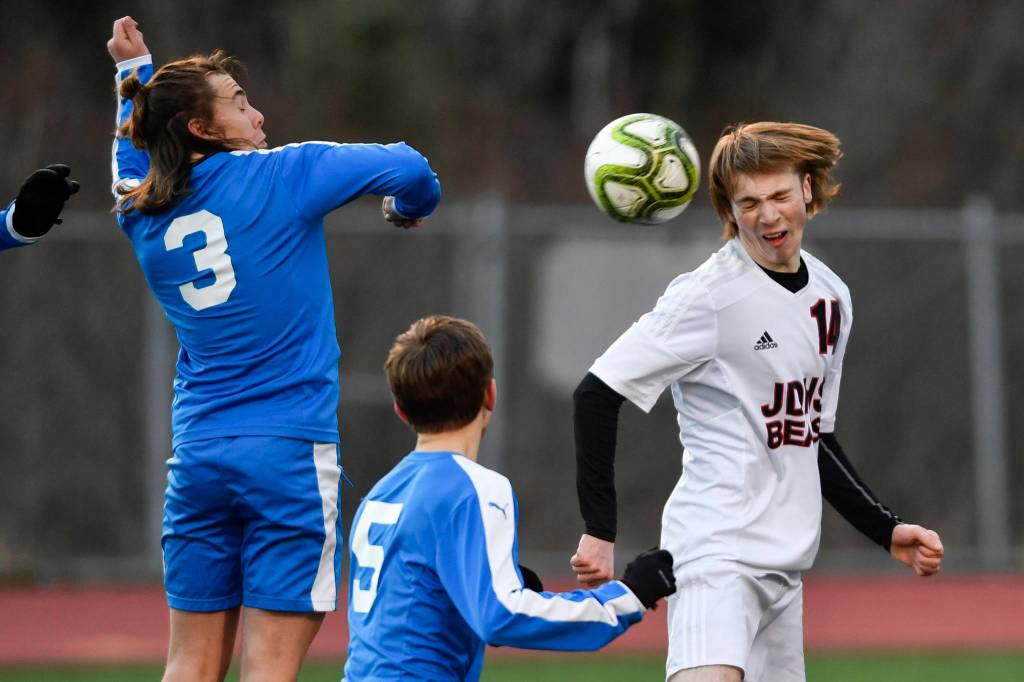 Juneau-Douglas Kanon Goetz, right, heads a shot against Thunder Mountains Gavin Gende, left, and Elias West during their game at TMHS on Tuesday, April 23, 2019. JDHS won 2-0. (Michael Penn | Juneau Empire)