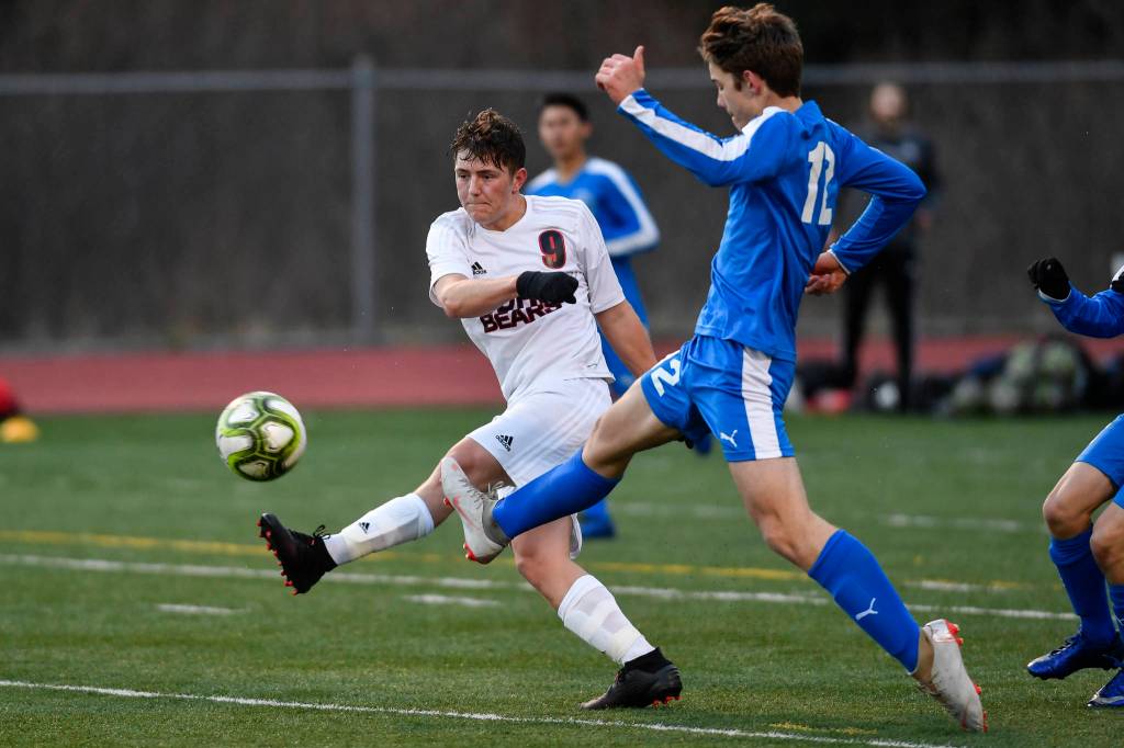 Juneau-Douglas Shey McCormick, left, takes a shot against Thunder Mountains Wallace Adams during their game at TMHS on Tuesday, April 23, 2019. JDHS won 2-0. (Michael Penn | Juneau Empire)