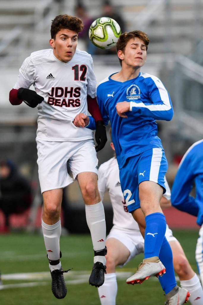 Juneau-Douglas Ronan Davies, left, takes a header against Thunder Mountains Wallace Adams during their game at TMHS on Tuesday, April 23, 2019. JDHS won 2-0. (Michael Penn | Juneau Empire)