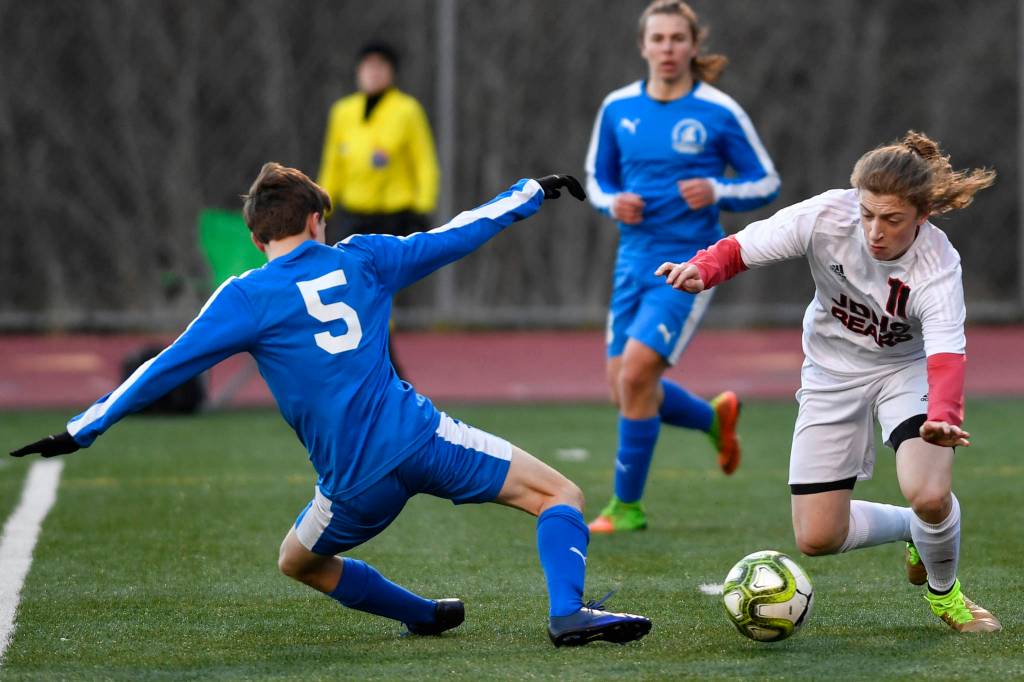 Juneau-Douglas Jackson Norberg dribbles around Thunder Mountains Elias West during their game at TMHS on Tuesday, April 23, 2019. JDHS won 2-0. (Michael Penn | Juneau Empire)