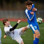 Thunder Mountains Wallace Adams, right, blocks a shot by Juneau-Douglas Koby Goldstein during their game at TMHS on Tuesday, April 23, 2019. JDHS won 2-0. (Michael Penn | Juneau Empire)