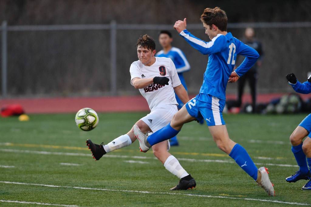Juneau-Douglas Shay McCormick, left, takes a shot against Thunder Mountains Wallace Adams during their game on Tuesday, April 23, 2019. (Michael Penn | Juneau Empire)