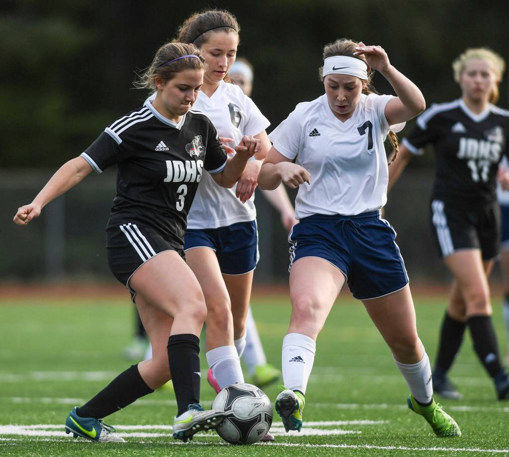 Juneau-Douglas Erica Hurtte, left, battles against Soldotnas Haley Buckbee, center, and Journey Miller at Adair-Kennedy Memorial Field on Friday, April 26, 2019. JDHS won 4-0. (Michael Penn | Juneau Empire)