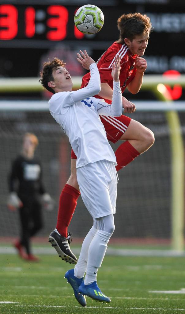 Juneau-Douglas Clem Taylor-Roth heads the ball against Soldotnas Josh Hieber at Adair-Kennedy Memorial Field on Friday, April 26, 2019. JDHS won 6-0. (Michael Penn | Juneau Empire)