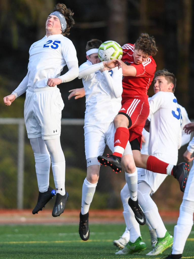Juneau-Douglas Richard Lehner goes the ball against Soldotnas Cameron Johnson, left, Lance Chilton, center, and Aiden Willets at Adair-Kennedy Memorial Field on Friday, April 26, 2019. JDHS won 6-0. (Michael Penn | Juneau Empire)
