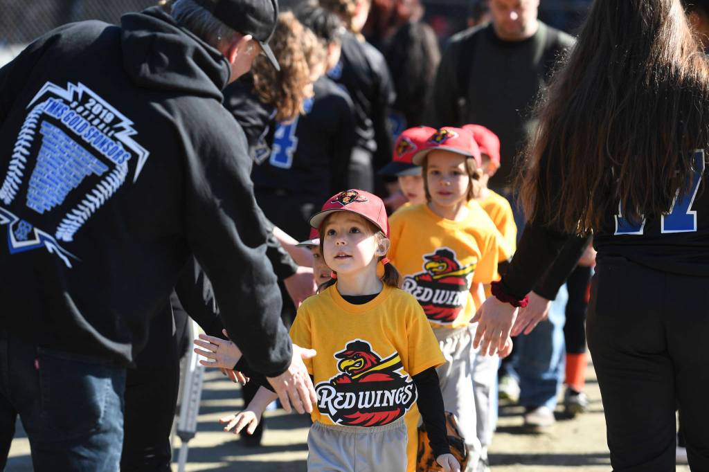 Players run a gauntlet of Thunder Mountain High School baseball and softball team players during the Gastineau Channel Little League Opening Day Ceremonies at Adair-Kennedy Memorial Park on Saturday, April 27, 2019. (Michael Penn | Juneau Empire)