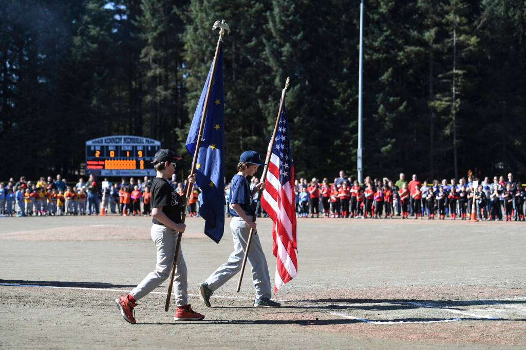 Jake and John Polasky bring out the colors during the Gastineau Channel Little League Opening Day Ceremonies at Adair-Kennedy Memorial Park on Saturday, April 27, 2019. (Michael Penn | Juneau Empire)