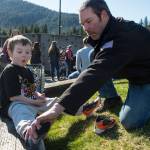 Noah Moore, 5, gets help with his shoes from his dad, James, before the Gastineau Channel Little League Opening Day Ceremonies at Adair-Kennedy Memorial Park on Saturday, April 27, 2019. (Michael Penn | Juneau Empire)
