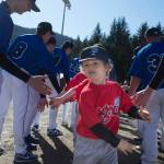 Players run a gauntlet of Thunder Mountain High School baseball and softball team players during the Gastineau Channel Little League Opening Day Ceremonies at Adair-Kennedy Memorial Park on Saturday, April 27, 2019. (Michael Penn | Juneau Empire)