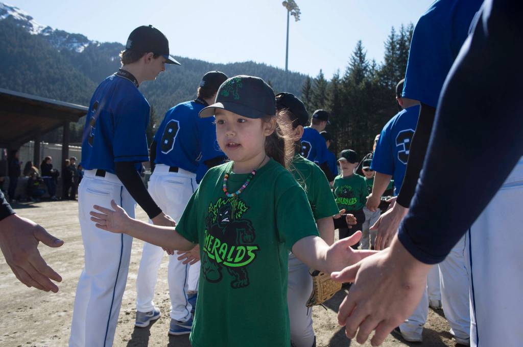 Players run a gauntlet of Thunder Mountain High School baseball and softball team players during the Gastineau Channel Little League Opening Day Ceremonies at Adair-Kennedy Memorial Park on Saturday, April 27, 2019. (Michael Penn | Juneau Empire)