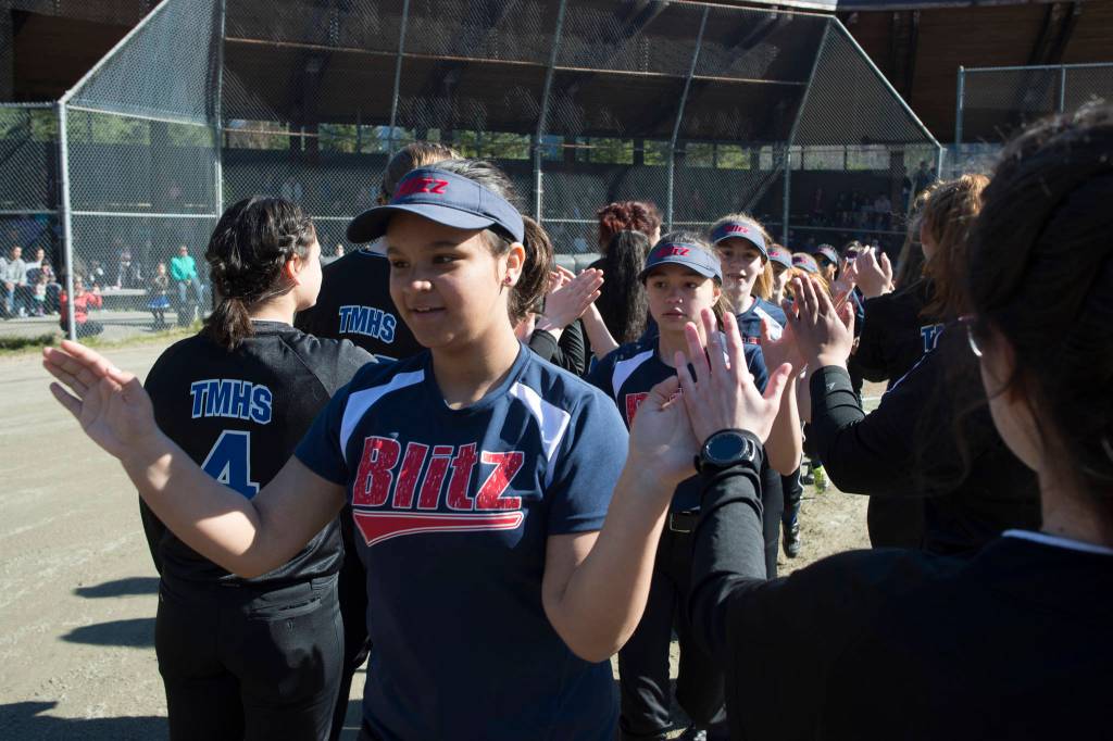 Players run a gauntlet of Thunder Mountain High School baseball and softball team players during the Gastineau Channel Little League Opening Day Ceremonies at Adair-Kennedy Memorial Park on Saturday, April 27, 2019. (Michael Penn | Juneau Empire)