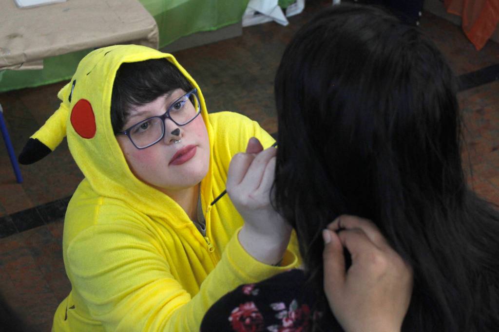 Natalie Chimelir of Juneaus Imagination Station paints Kailey Cannons face at the Alaska Robotics Mini-Con on Saturday, April 27, 2019. (Alex McCarthy | Juneau Empire)
