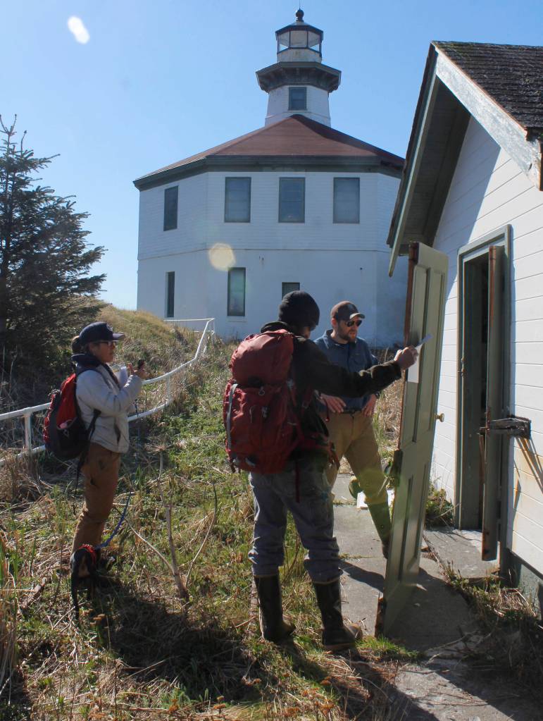 Eldred Rock Lighthouse Preservation Association Executive Director Sue York and board members Justin Fantasia and Jonathan Wood examine a broken door at Eldred Rock Lighthouse on Monday, April 29, 2019. (Alex McCarthy | Juneau Empire)