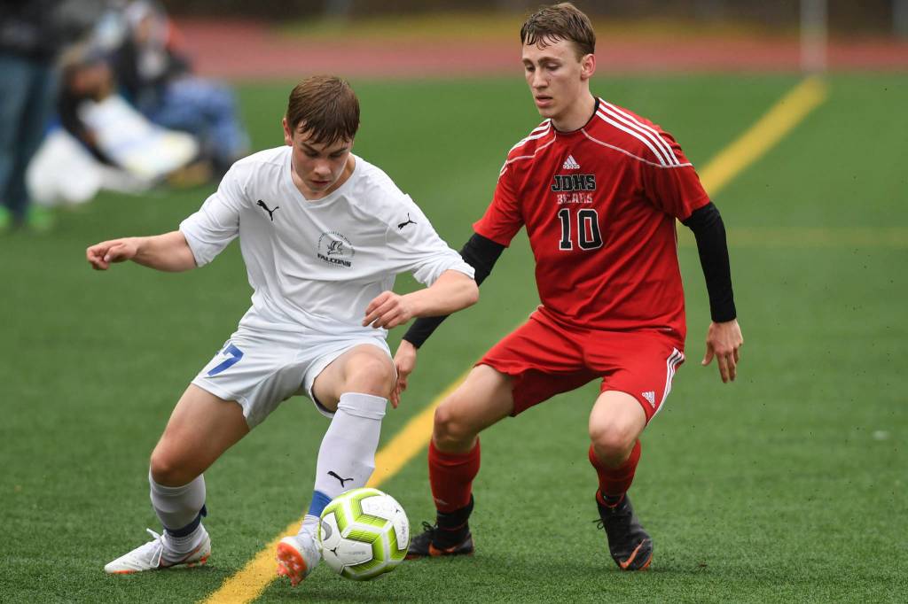 Thunder Mountains Logan Miller, left, moves the ball against Juneau-Douglas Aiden Hopson at Adair-Kennedy Memorial Field on Tuesday, May 7, 2019. The game ended tied at 1-1. (Michael Penn | Juneau Empire)