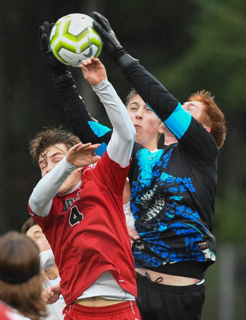 Thunder Mountains goal keeper Caleb Traxler knocks the ball away from Juneau-Douglas William Hoover at Adair-Kennedy Memorial Field on Tuesday, May 7, 2019. The game ended tied at 1-1. (Michael Penn | Juneau Empire)