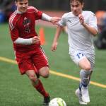Thunder Mountains Logan Miller, right, races against Juneau-Douglas William Hoover at Adair-Kennedy Memorial Field on Tuesday, May 7, 2019. The game ended tied at 1-1. (Michael Penn | Juneau Empire)