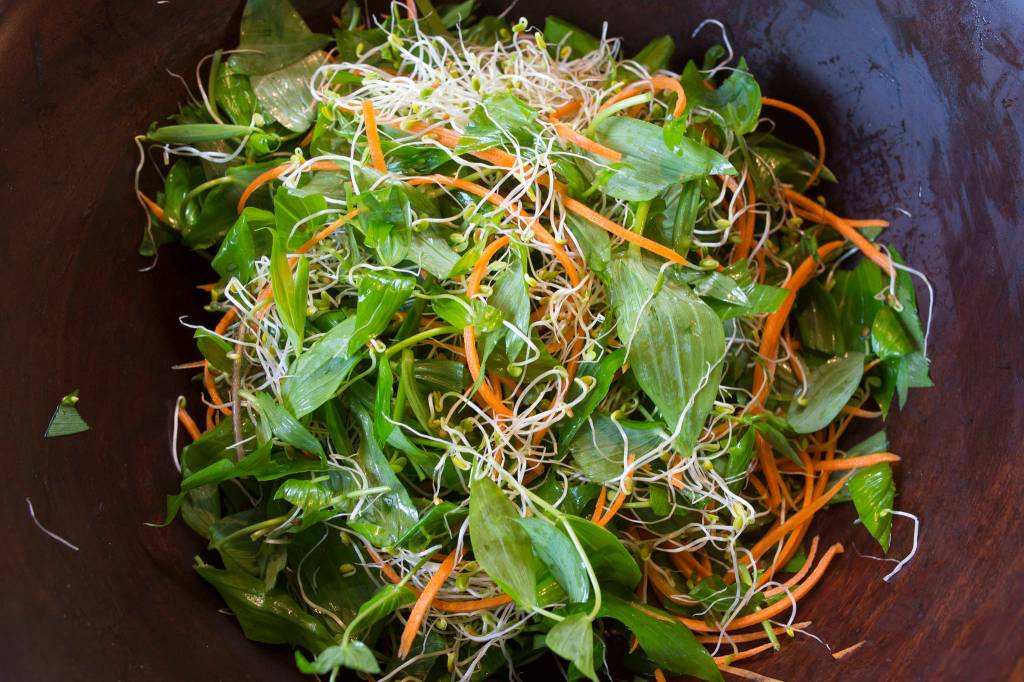Erin Anais Heist prepares twisted stalk salad to go with crab cakes on Friday, May 10, 2019. (Michael Penn | Juneau Empire)
