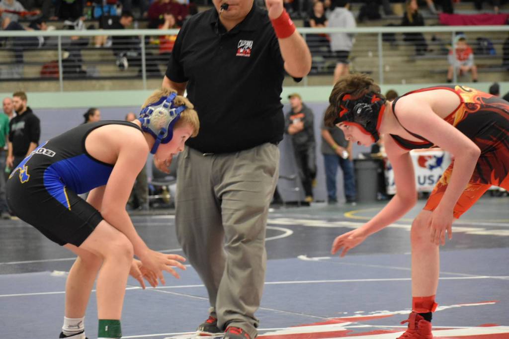Sage Schultz, left, gets in the ready position while wrestling in the 102-pound weight class at the Alaska State Wrestling Championships. (Courtesy Photo | Nikki Schultz)