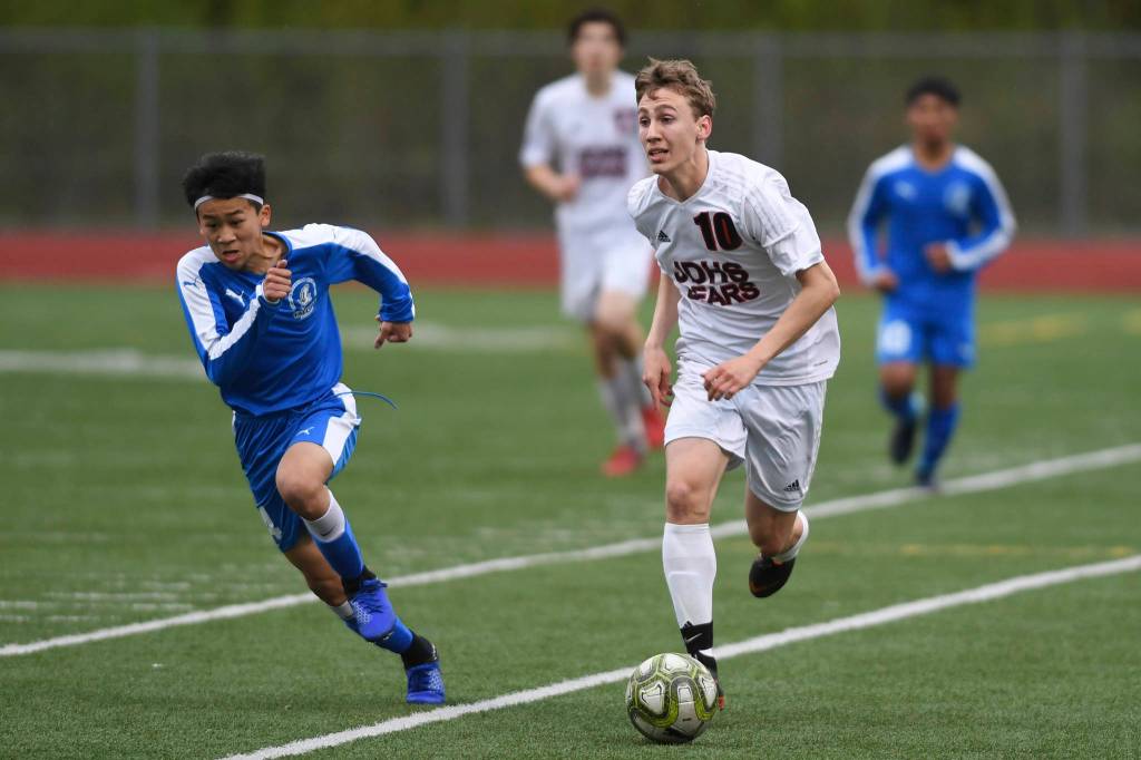 Juneau-Douglas Aiden Hopson, right, races against Thunder Mountains Phillip Lam at TMHS on Tuesday, May 14, 2019. JDHS won 5-1. (Michael Penn | Juneau Empire)