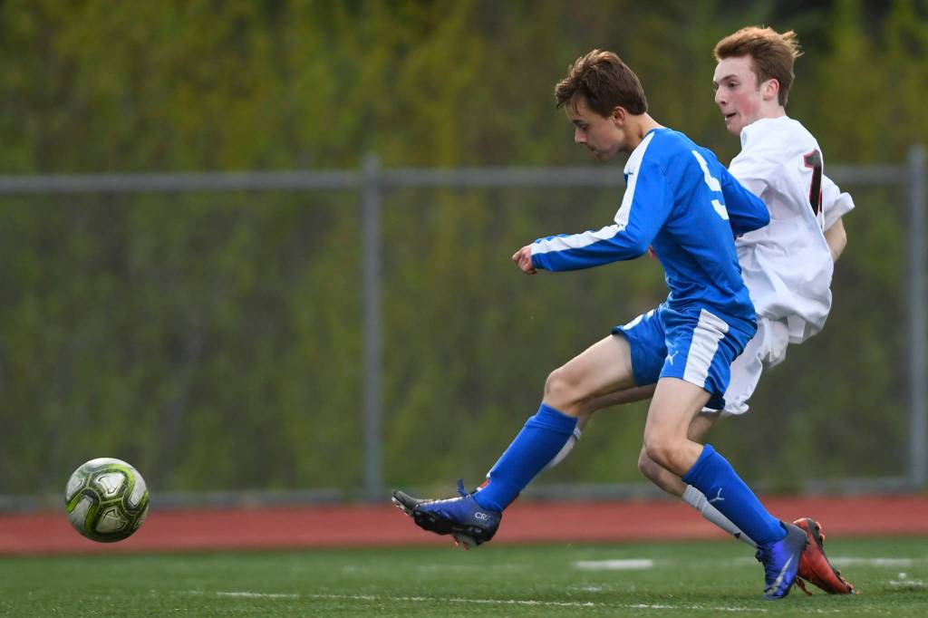 Juneau-Douglas Kanon Goetz kicks a goal against Thunder Mountains Elias West at TMHS on Tuesday, May 14, 2019. JDHS won 5-1. (Michael Penn | Juneau Empire)