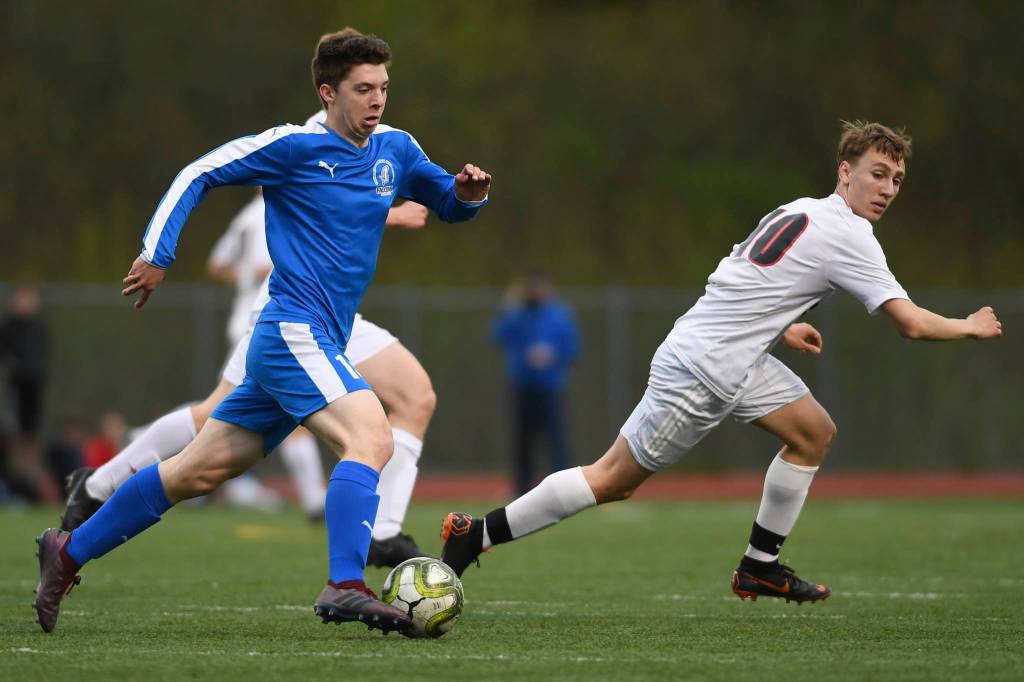 Thunder Mountains Jake Babcock, left, moves the ball against Juneau-Douglas Aiden Hopson at TMHS on Tuesday, May 14, 2019. JDHS won 5-1. (Michael Penn | Juneau Empire)