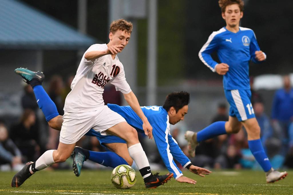 Thunder Mountains Marc Manlulu falls as Juneau-Douglas Aiden Hopson takes the ball at TMHS on Tuesday, May 14, 2019. JDHS won 5-1. (Michael Penn | Juneau Empire)