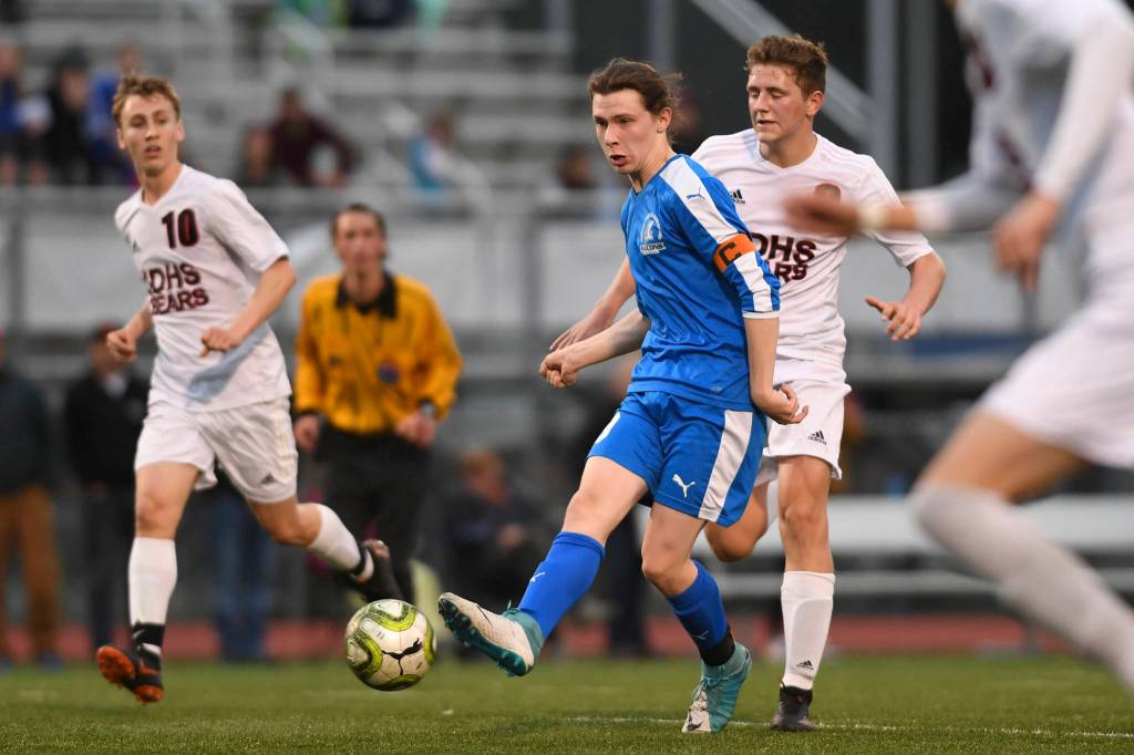 Thunder Mountains Shay McCormick moves the ball against Juneau-Douglas Richard Lehner, right, and Aiden Hopson at TMHS on Tuesday, May 14, 2019. JDHS won 5-1. (Michael Penn | Juneau Empire)