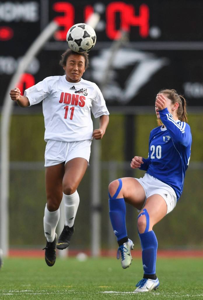 Juneau-Douglas Malia Miller heads the ball against Thunder Mountains Riley Traxler at TMHS on Tuesday, May 14, 2019. JDHS won 3-0. (Michael Penn | Juneau Empire)