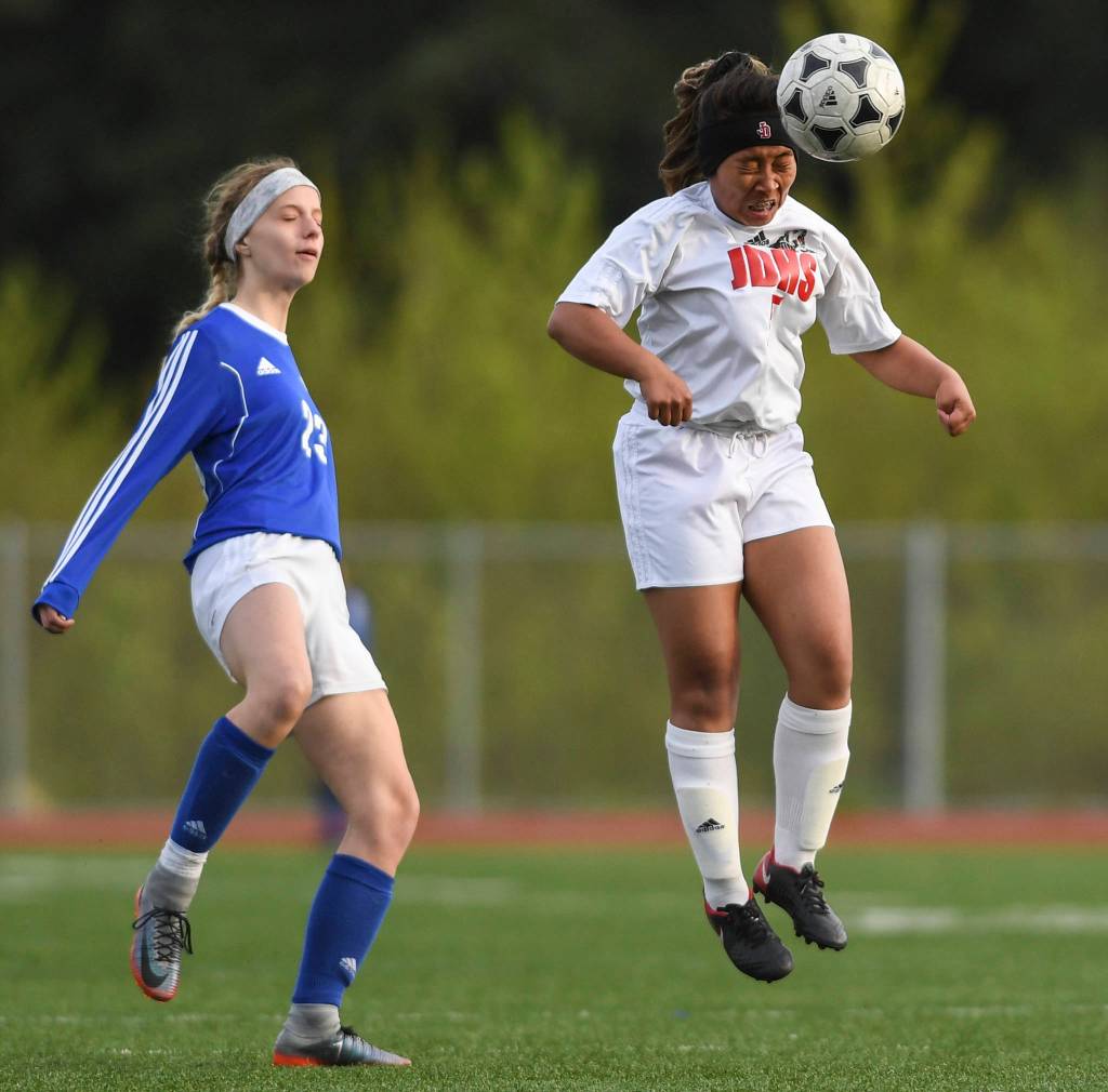 Juneau-Douglas Asianna Mazon, right, heads the ball against Thunder Mountains Isabella Hanna at TMHS on Tuesday, May 14, 2019. JDHS won 3-0. (Michael Penn | Juneau Empire)