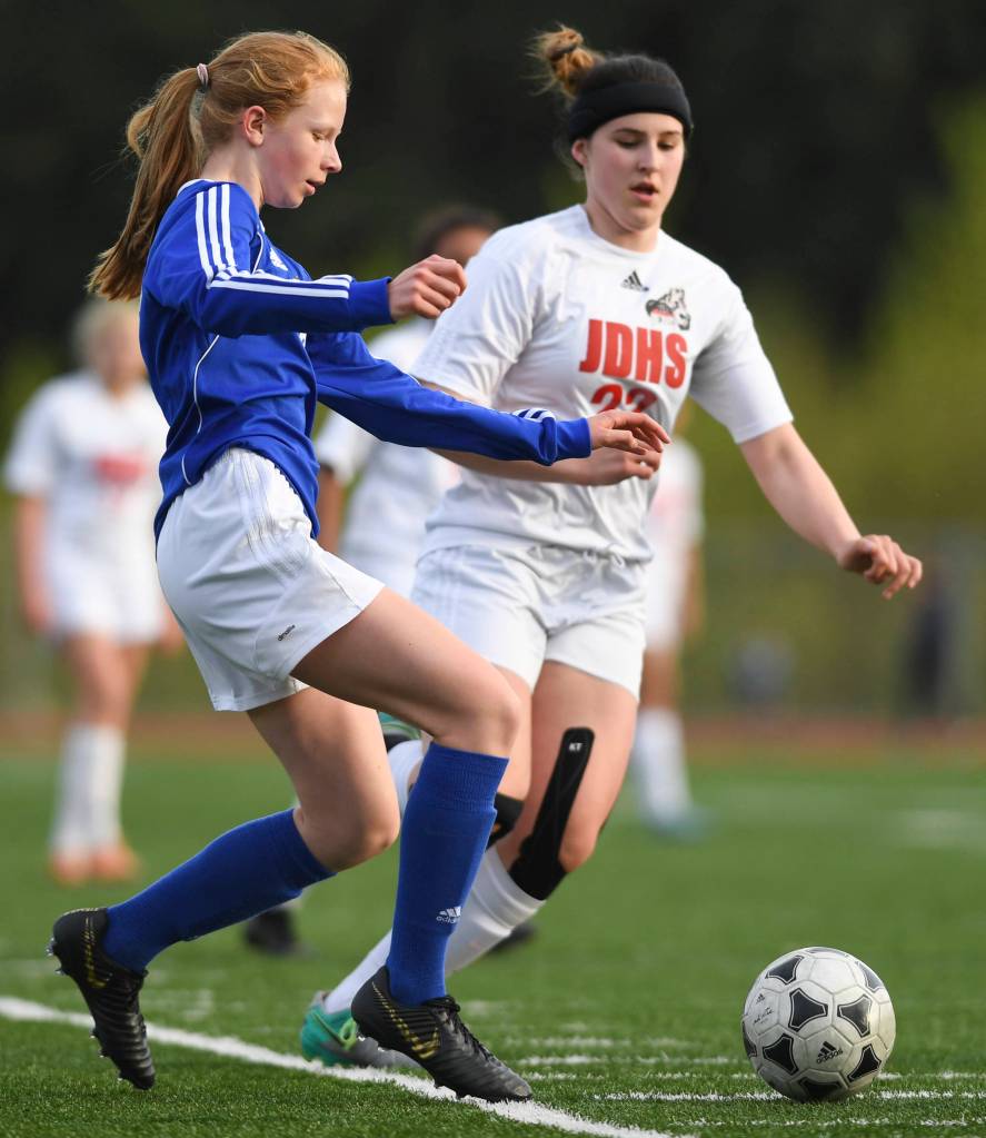 Thunder Mountains Julia Robinson, left, kicks the ball away from Juneau-Douglas Nikki Box at TMHS on Tuesday, May 14, 2019. JDHS won 3-0. (Michael Penn | Juneau Empire)