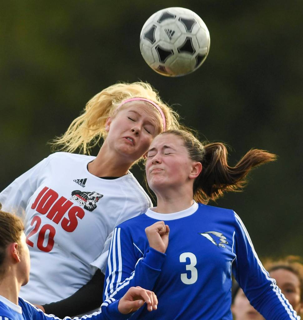Juneau-Douglas Michaela Bentley, left, attempts to head a corner kick against Thunder Mountains Macey Fuette at TMHS on Tuesday, May 14, 2019. JDHS won 3-0. (Michael Penn | Juneau Empire)