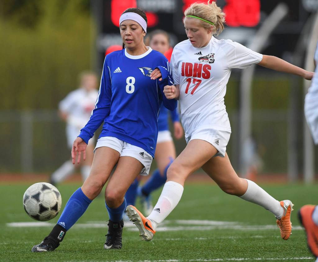 Thunder Mountains Keana Villanueva, left, kicks the ball away from Juneau-Douglas Taylor Bentley at TMHS on Tuesday, May 14, 2019. JDHS won 3-0. (Michael Penn | Juneau Empire)