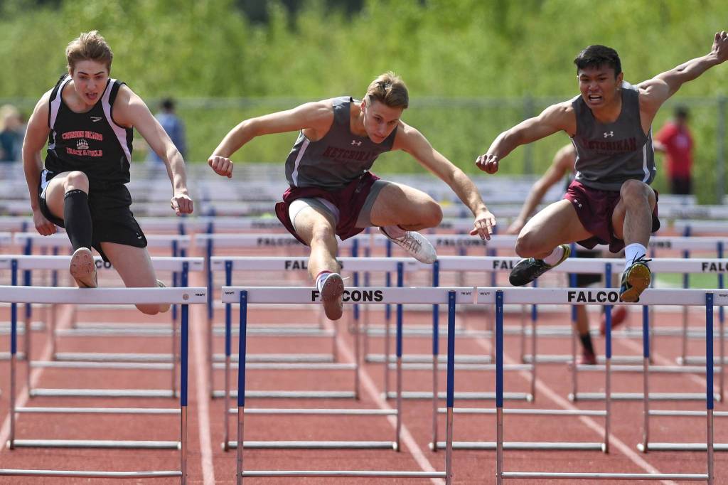 Ketchikans Ivers Credito, right, leads his teammate Christopher Carlson, center, and Juneau-Douglas Tyler Weldon in the boys 110 meter hurdles at the Region V Track and Field Championships at Thunder Mountain High School on Saturday, May 18, 2019. (Michael Penn | Juneau Empire)
