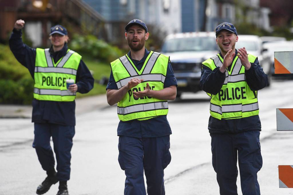 Personnel from the U.S. Coast Guards Sector Juneau cheer on students as Harborview Elementary School holds its annual Fun Run along Glacier Avenue on Friday, May 17, 2019. Students from Montessori Borealis also ran the three-mile course. (Michael Penn | Juneau Empire)